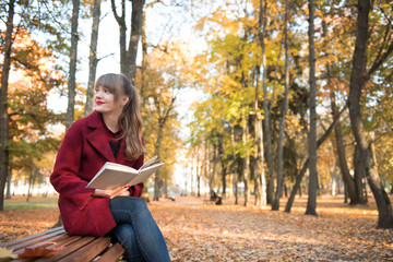 Woman with book on bench in park