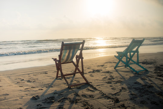 silla de playa en amanecer son la luz del sol junto a la arena