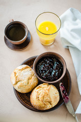 Simple breakfast: coffee americano, fresh buns with jam and juice.
