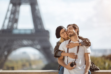 Paris Eiffel tower romantic tourist couple embracing kissing in front of Eiffel Tower, Paris,...