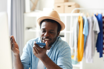 African young man talking on his mobile phone while working at office