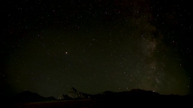 the night starry sky is moving over the mountain range. time lapse