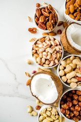 Various types of nuts - walnuts, pecans, peanuts, hazelnuts, coconut, almonds, cashews, in bowls