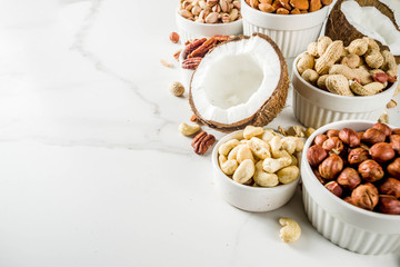 Various types of nuts - walnuts, pecans, peanuts, hazelnuts, coconut, almonds, cashews, in bowls