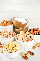 Various types of nuts - walnuts, pecans, peanuts, hazelnuts, coconut, almonds, cashews, in bowls