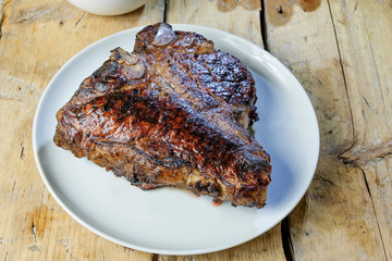 Round dish with grilled porterhouse beef steak