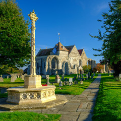 Early evening autumn light on St Thomas the Martyr church and village cross, Winchelsea, East...