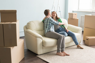 New home, moving and real estate - Happy couple sitting on sofa and discussing new flat