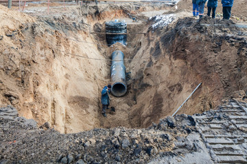 sewer pipe in the trench . Urban construction of a trench in the ground during the repair of water and sewer pipes is fenced.