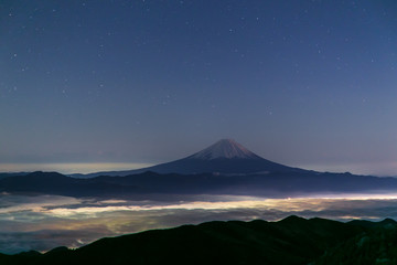 Fototapeta na wymiar 国師ヶ岳山頂から富士山と冬の星空