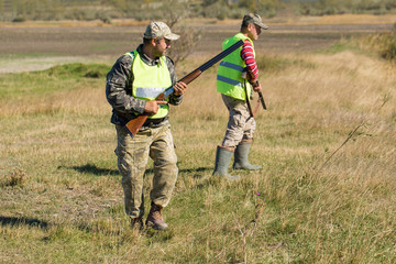 Hunters with a german drathaar and spaniel, pigeon hunting with dogs in reflective vests