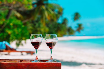 two wine glasses on tropical sand beach vacation