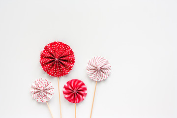 Red and white paper fan with wooden stick on white background for party decoration