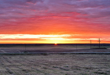 Sunrise over the field and the road
