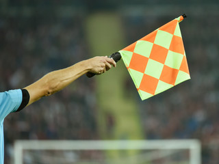 Fototapeta premium Raised hand with flag of assistant soccer referee