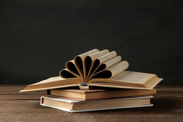 A stack of books on a brown wooden table and on a black background. Old books. Education. school. study