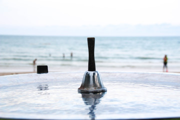 The bell has a backdrop of sea.