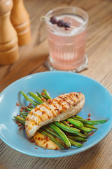 fried chicken, sauce and green beans on the blue plate with blackberry alcohol cocktail on the table