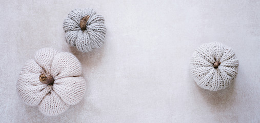 Kuschelige Kürbisse aus Wolle auf einem rustikalen, grungy Untergrund, im Banner Format und mit Textfreiraum 