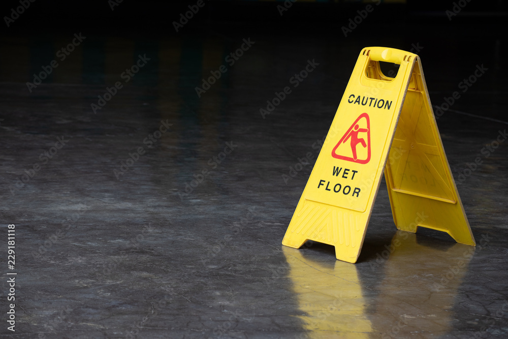 Wall mural wet floor sign on cement ground. yellow plastic warning sign.