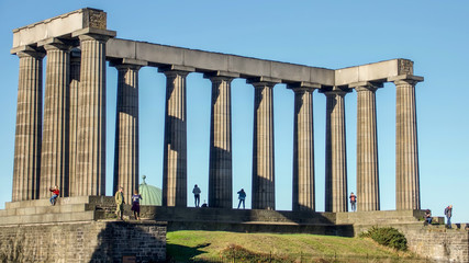 Calton Hill on a bright autumn day.  Tourists on the National Monument.