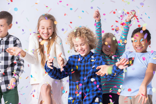 Happy boy have fun during birthday party with smiling friends with confetti