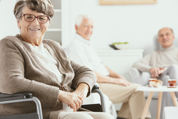 Fototapeta premium Happy paralyzed senior woman on wheelchair in the nursing house