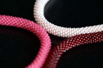 Set of three beaded bracelets on a dark background close up