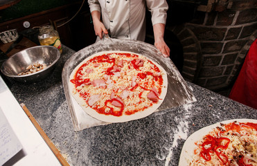 Cheese pizza on a wooden shovel. Preparation for placing in the oven