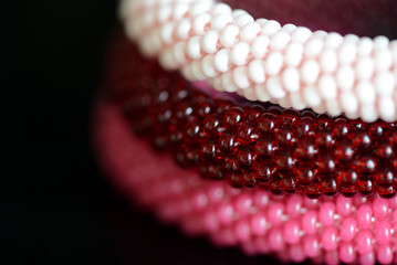 Set of three beaded bracelets on a dark background close up