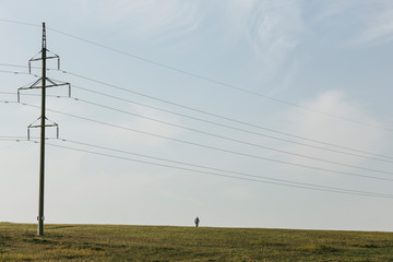 lonely person in the field near the high-voltage line