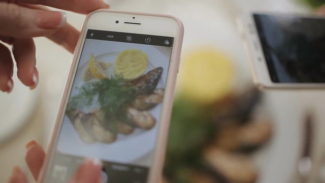 Take a photo picture of food in a restaurant with mobile phone camera for social network