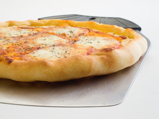 Detalle en primer plano de una pizza 4 quesos y utensilio para servirla4