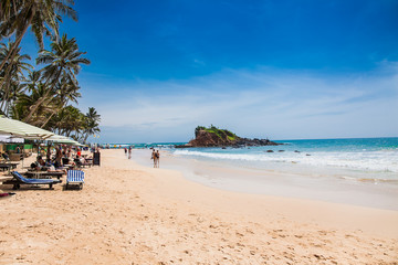 Fototapeta na wymiar Tourists on wonderful beach of Mirissa, Sri Lanka.