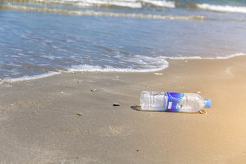 Fototapeta na wymiar Closeup bottle plastic garbage on the beach,Trash on sand beach showing environmental pollution problem