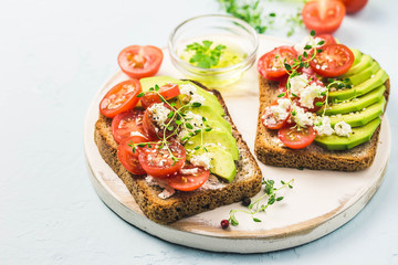 Avocado tomatoes goat cheese sandwiches. Selective focus, space for text.