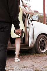 Naklejka premium Thief Dangerous man or masked robber holding a gun standing behind the woman