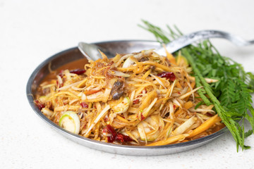 Papaya salad with pickled fish and many herbs in silver tray. Street foods found in Thailand and general restaurants. It has a delicious and spicy taste. Soft focus and blur.