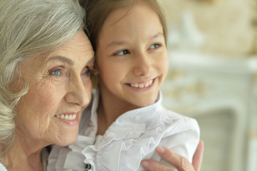 Portrait of happy grandmother and granddaughter posing