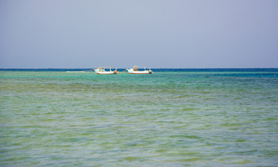 Fototapeta na wymiar Blue seascape with two sailing boats in the sea far away
