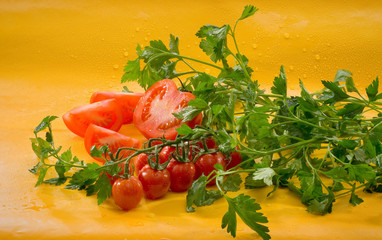 Овощи - помидоры, петрушка на желтом фоне Vegetables - tomatoes, parsley on a yellow background