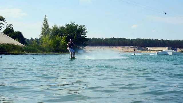 Wakeboarder rides into camera and crash into water on his wake board slow motion