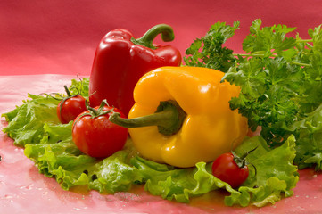 Овощи - помидоры, перец, салат, на красном фоне Vegetables - tomatoes, peppers, lettuce on a red background