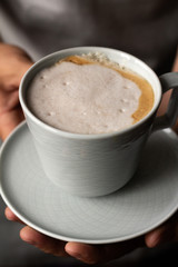 cup of cappuccino in male hands.