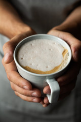 man's hands hold a cup of coffee close up.