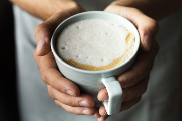 men's hands hold a cup of coffee.