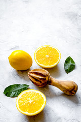 cut oranges and wooden juicer on concrete background top view