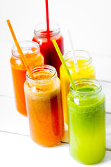 Fresh detox juices in glass bottles on white background
