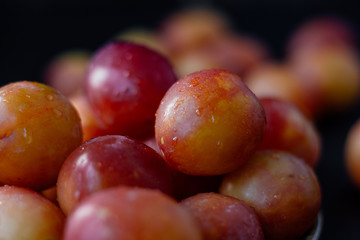 Ripe and beautiful wild plum fruits over black background.