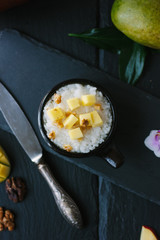Top view of mango and rice dessert over black background.